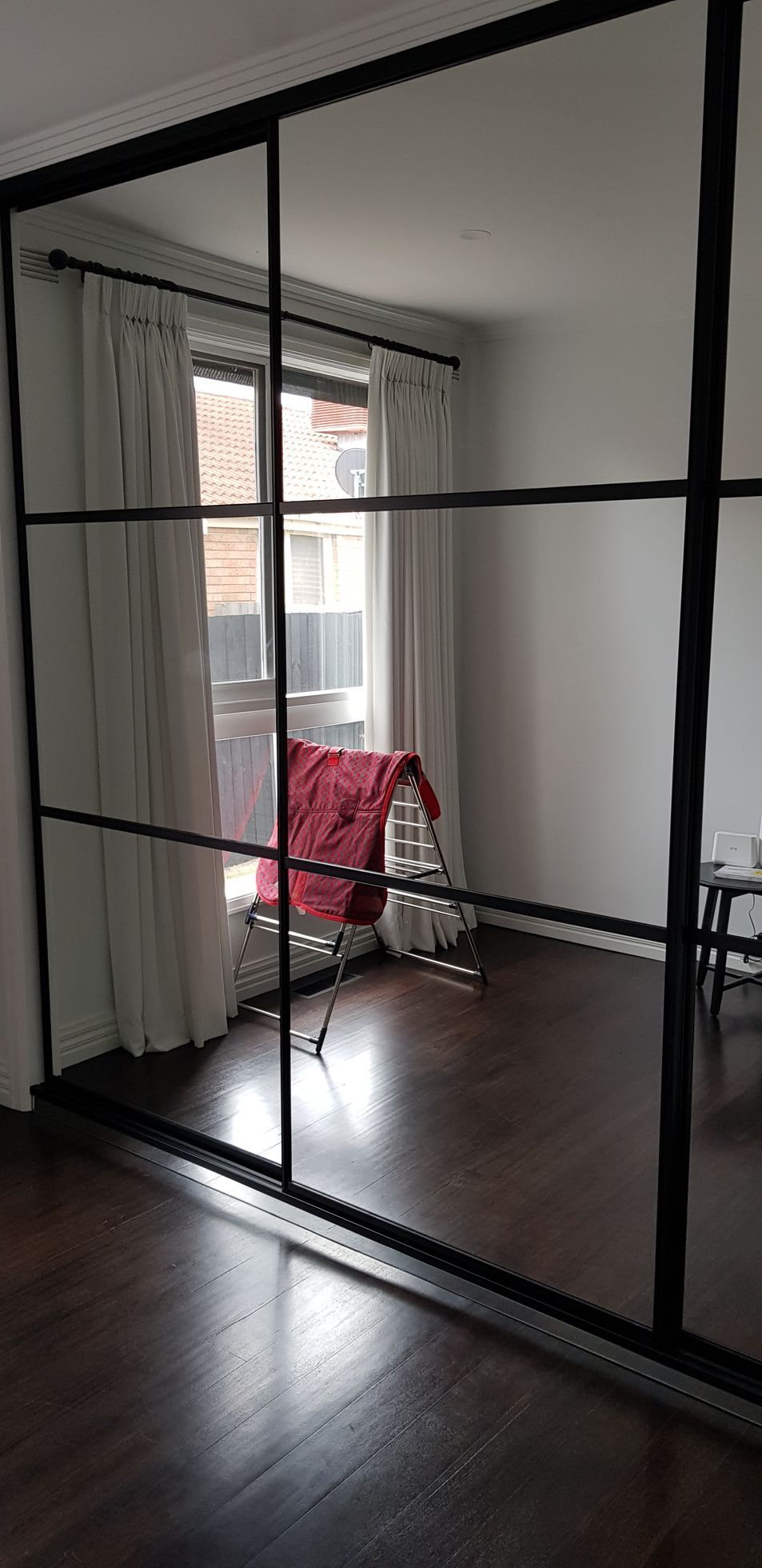 A living room with a large mirrored sliding glass door.