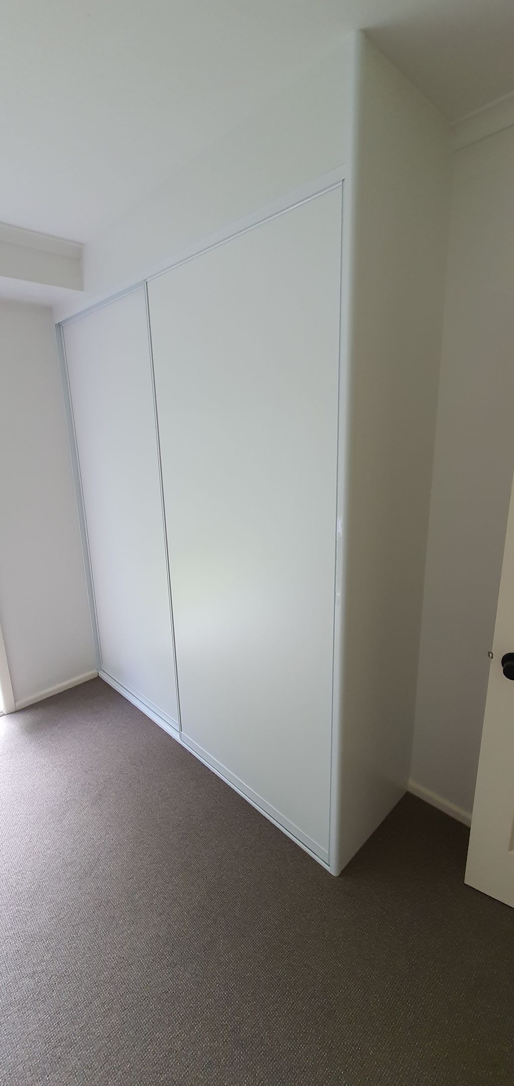 There is a large white wall in the middle of the room.