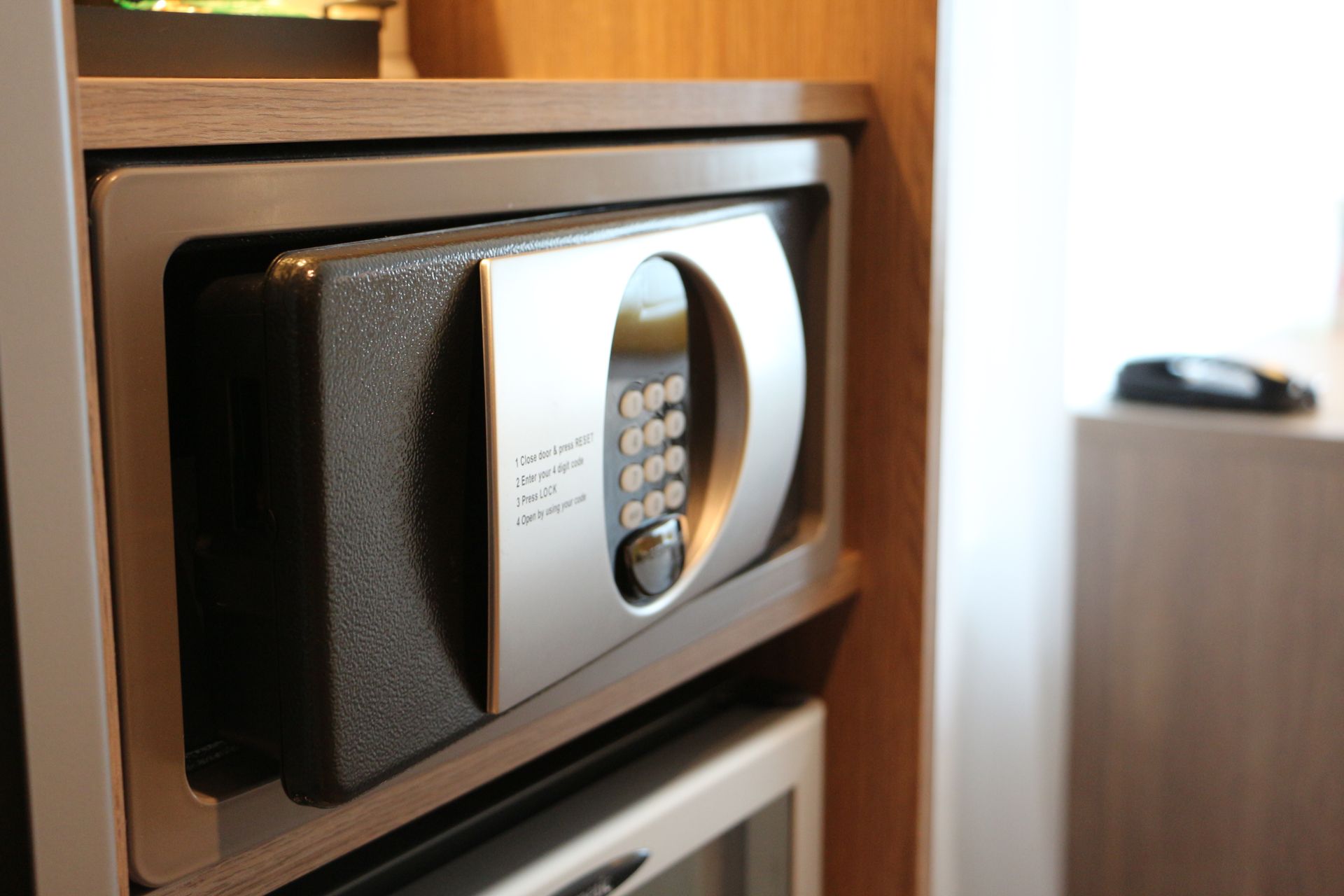 Open wall-mounted home safe with a keypad lock inside a home