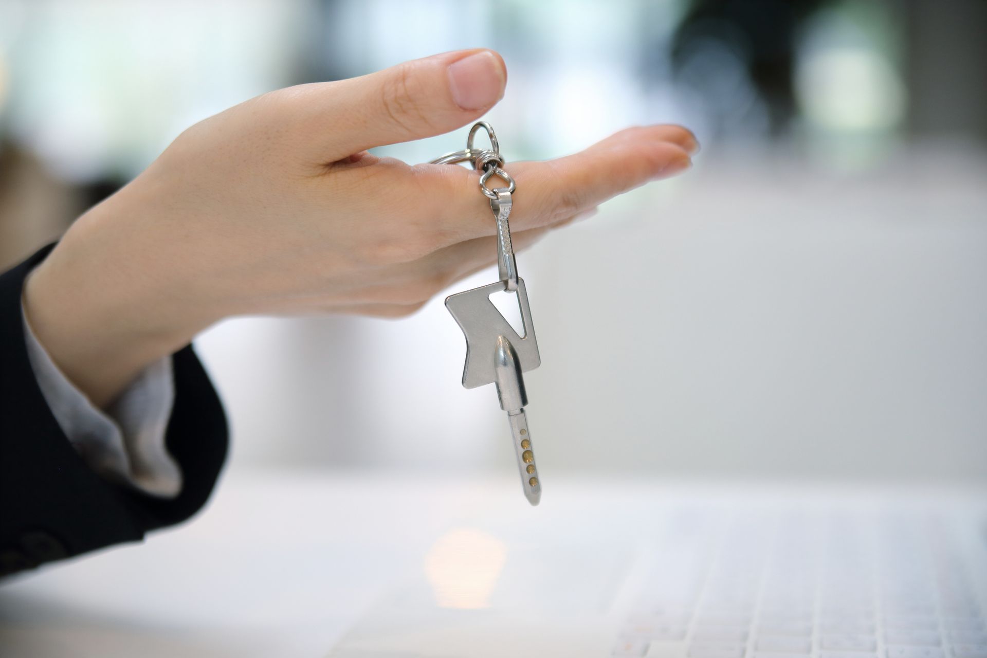 A close-up of an individual holding a key, showcasing the importance of commercial re-keys.