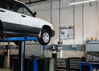A car is sitting on top of a lift in a garage.