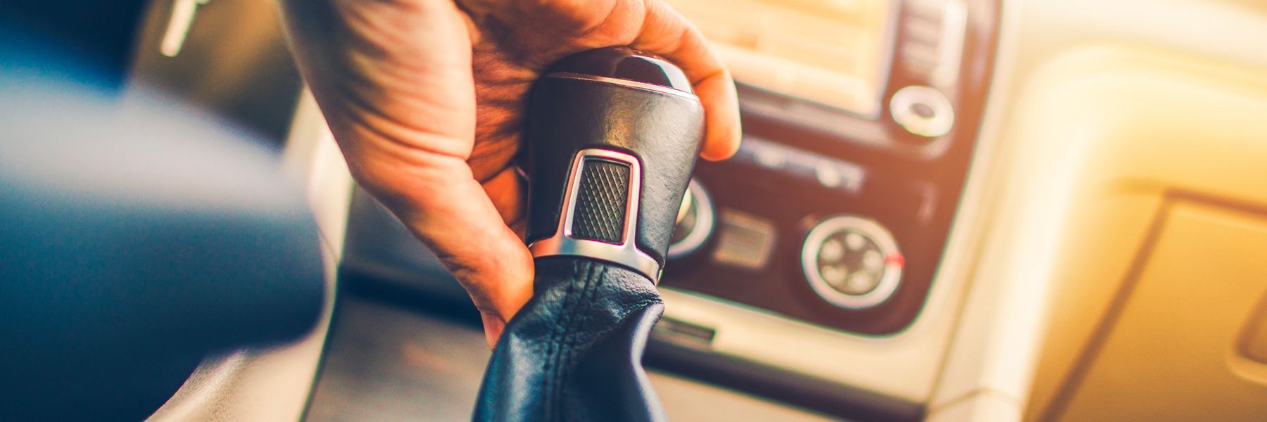 A person is holding a car gear shift in their hand.