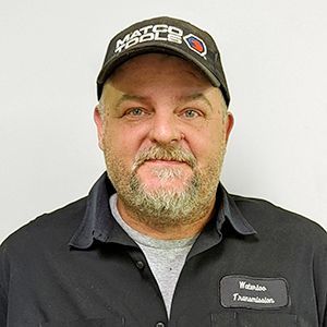 A man with a beard is wearing a hat and a black shirt.