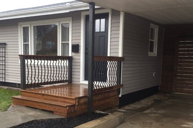 A screened in porch with a wooden deck and a ceiling fan