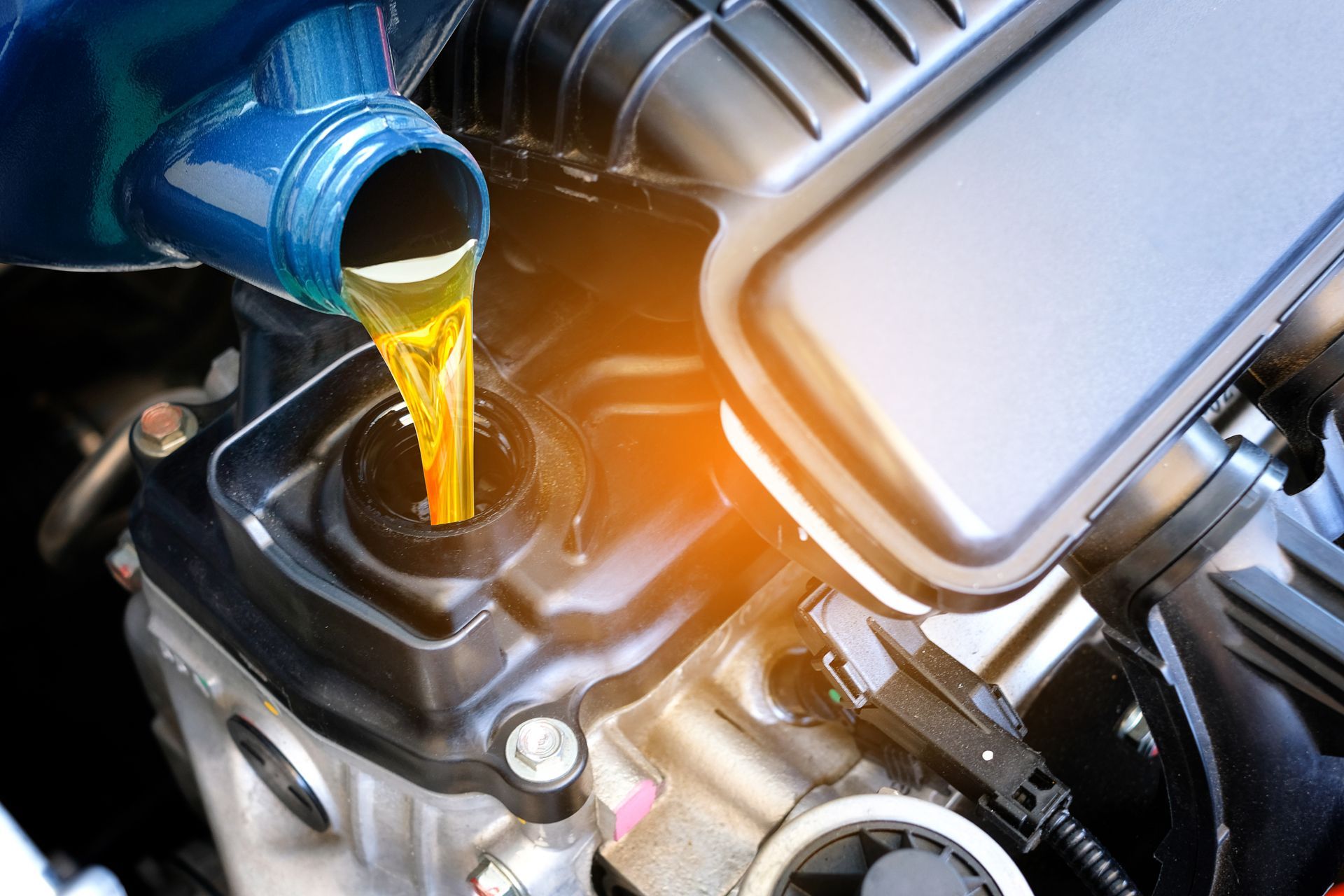 Pouring motor oil into a car engine
