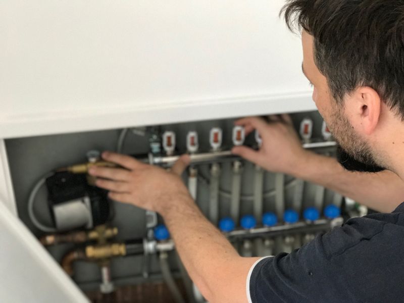 Worker Checking And Adjusting The Heat System Pipes - Lexington, NC - Central Services