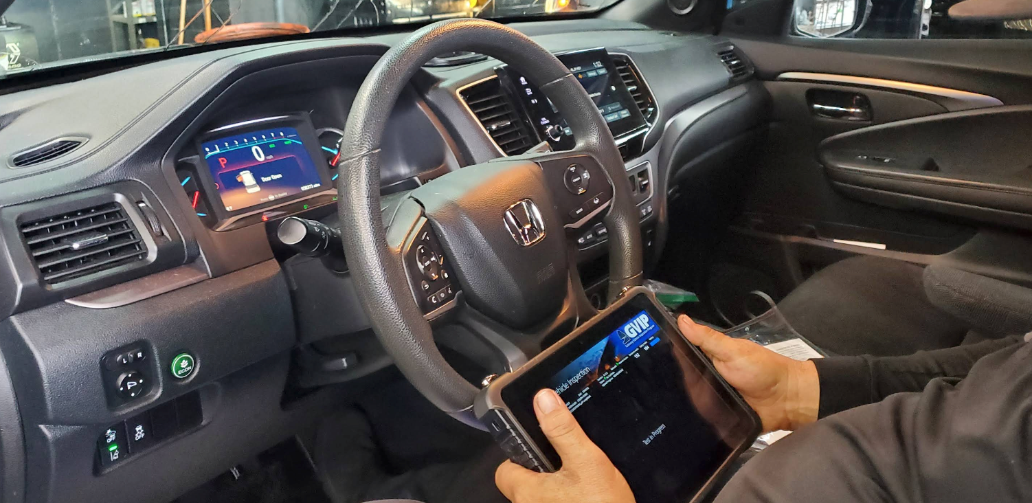 A technician uses a tablet to perform a diagnostic check on the interior dashboard of a Honda vehicle | 55 Tires and Service