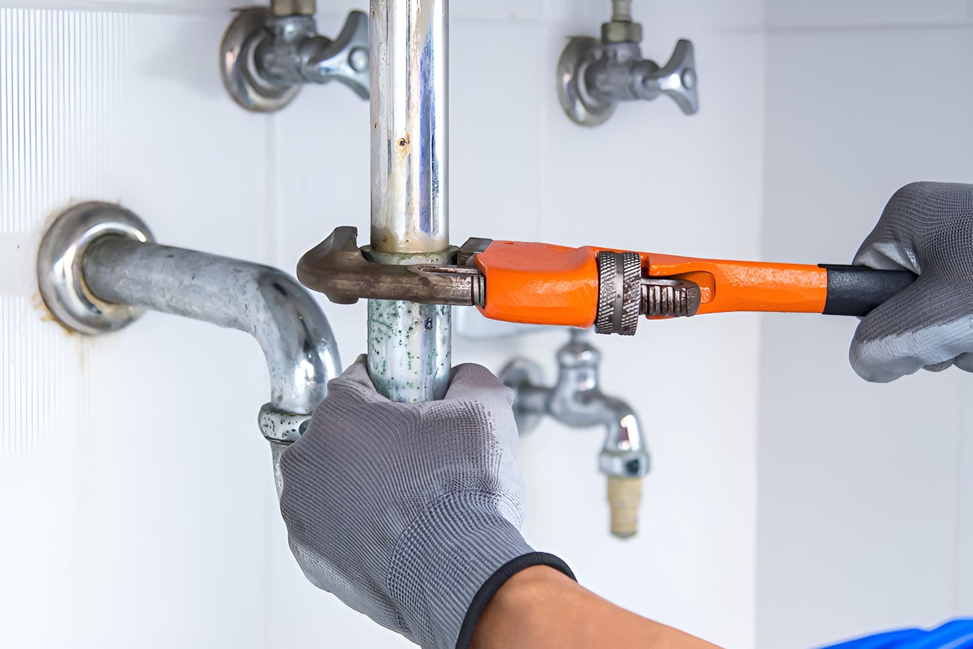 A Plumber is Fixing a Sink Pipe With a Wrench — Simpson's Plumbing & Maintenance Service in Dakabin, QLD