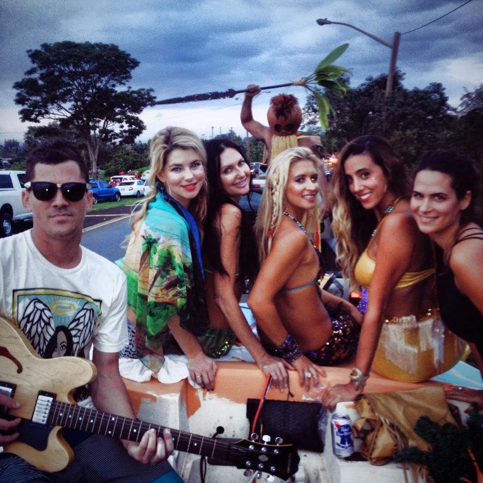 A man is playing a guitar in front of a group of women