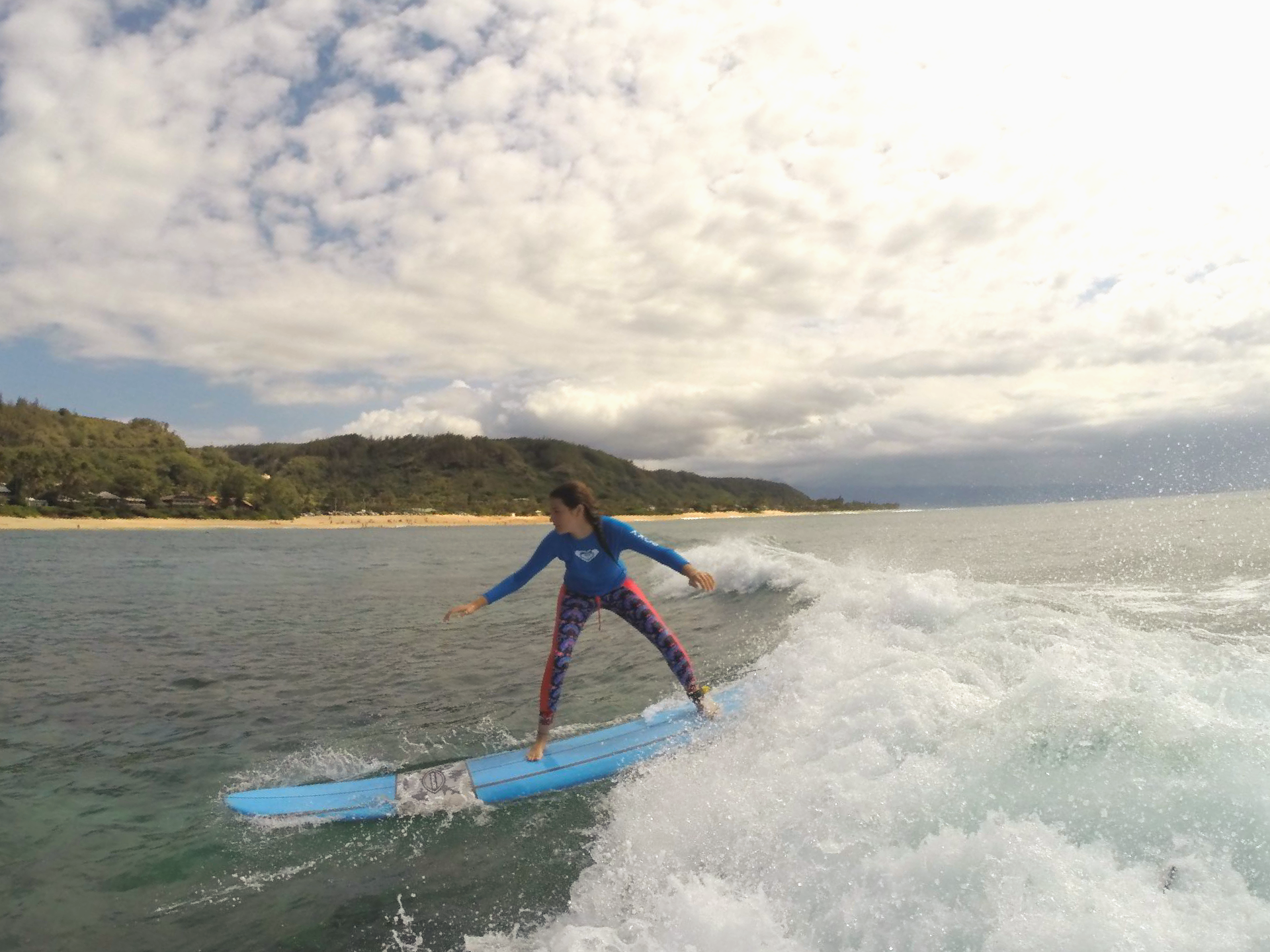 A woman is riding a wave on a surfboard in the ocean.