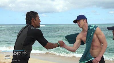 Two men are shaking hands on the beach.