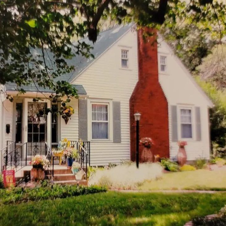 a white house with a red chimney on the front