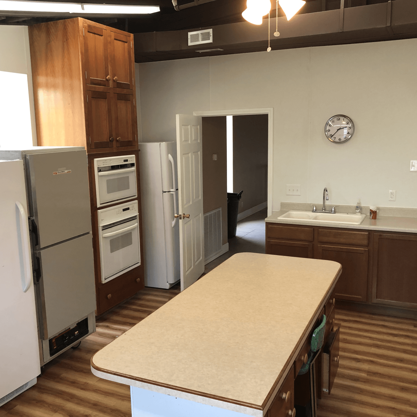 a kitchen with a large island and a clock on the wall