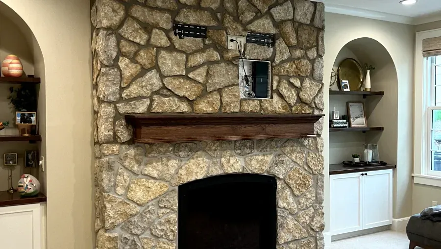 A living room with a fireplace and a stone wall.