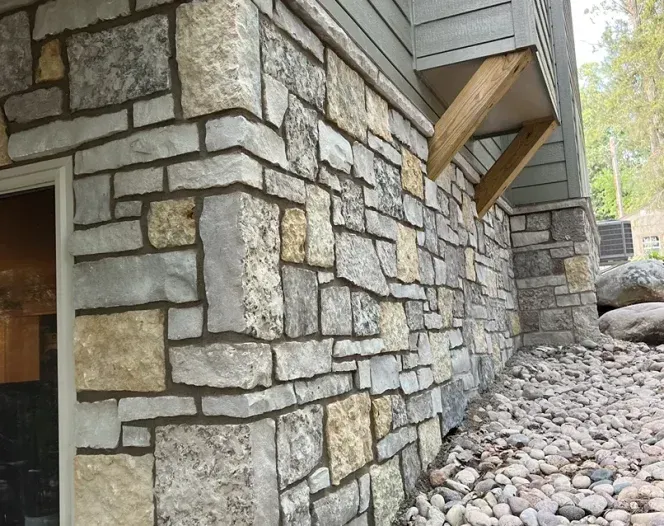 A stone wall with a wooden beam on the side of it