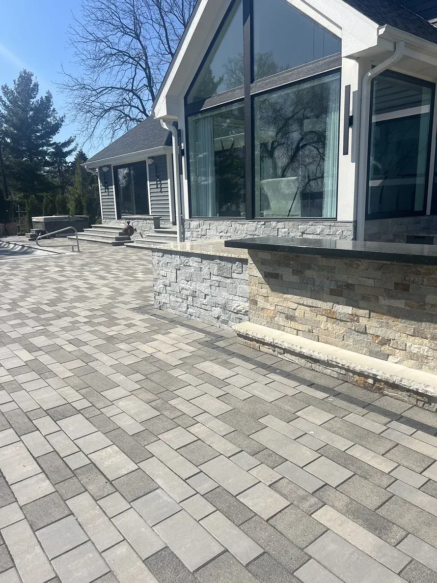 A large house with a brick driveway in front of it.