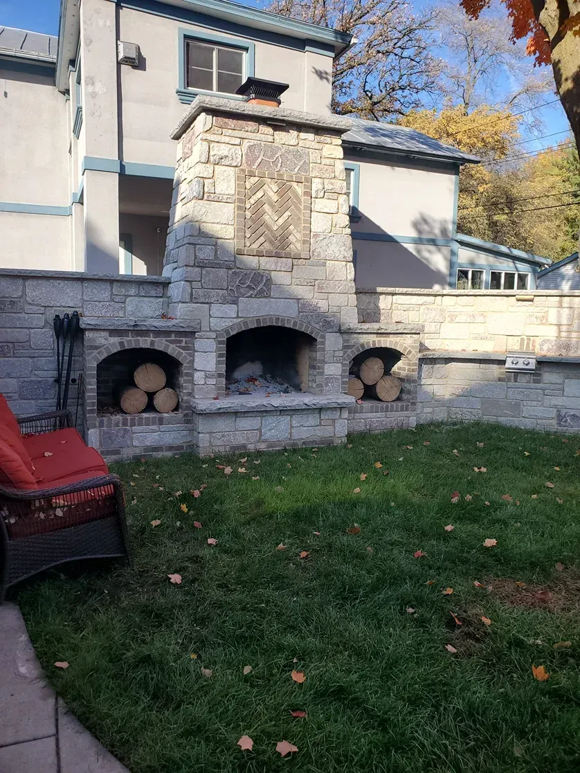 There is a fireplace in the backyard of a house.