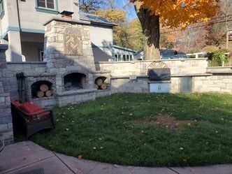 There is a fireplace in the backyard of a house.