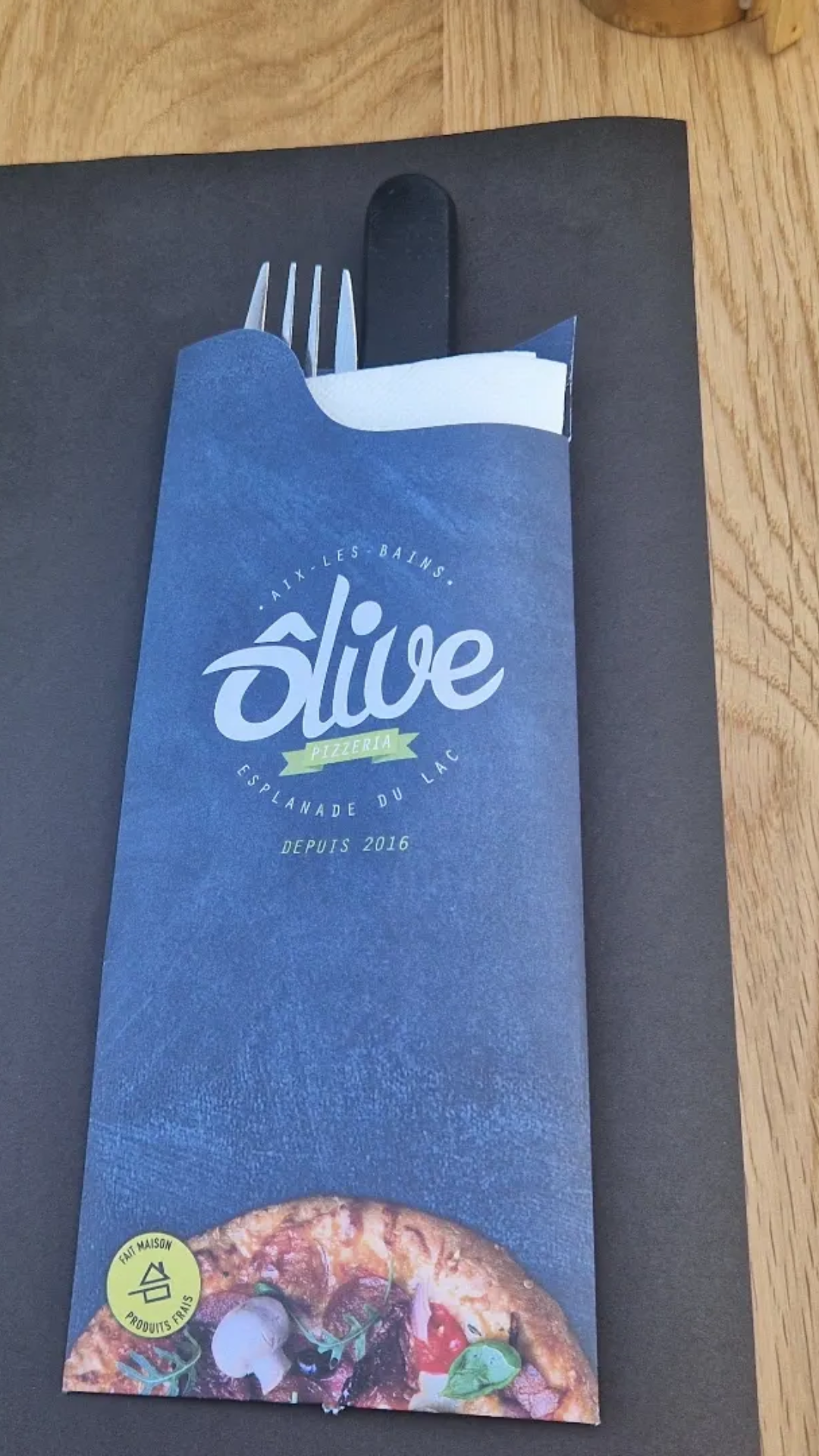 Fourchette et couteau dans une pochette en papier bleu au restaurant Olive.
