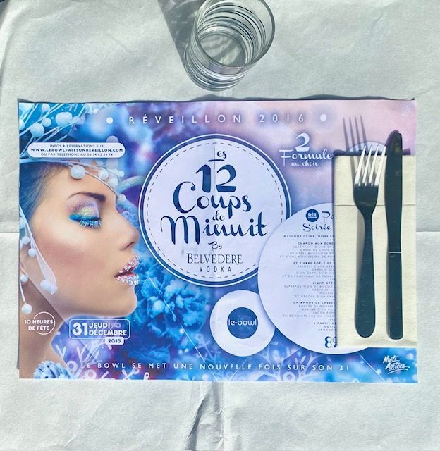 Couvert avec un motif à thème bleu, un visage de femme, des couverts et un verre.
