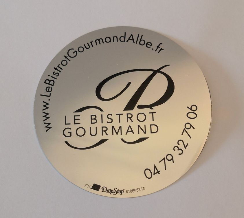 Enseigne circulaire argentée pour le restaurant Le Bistrot Gourmand, avec logo et coordonnées.