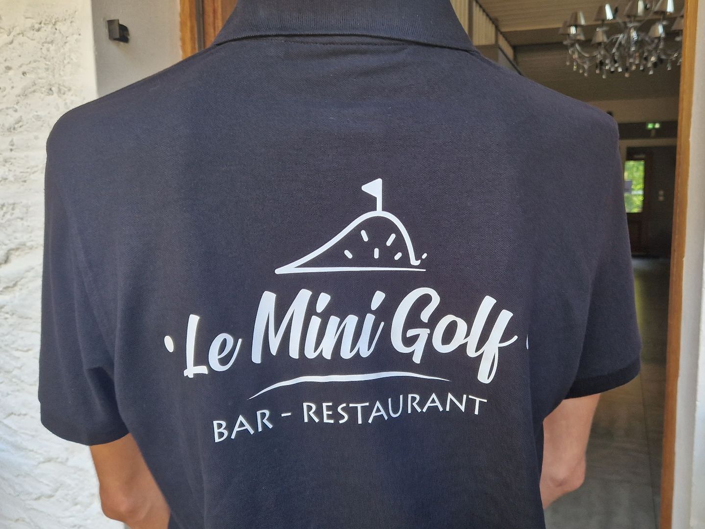 Dos d'un polo noir avec un logo blanc 