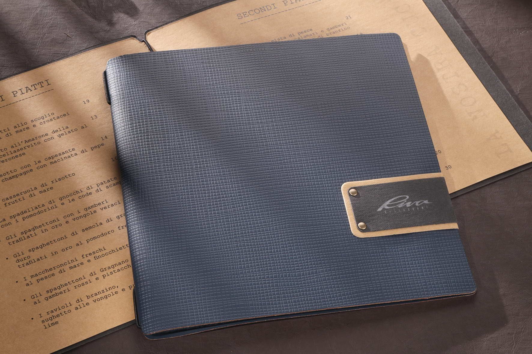 Chemise en cuir bleu sur papiers ; plaque signalétique dorée indiquant « Liora ».