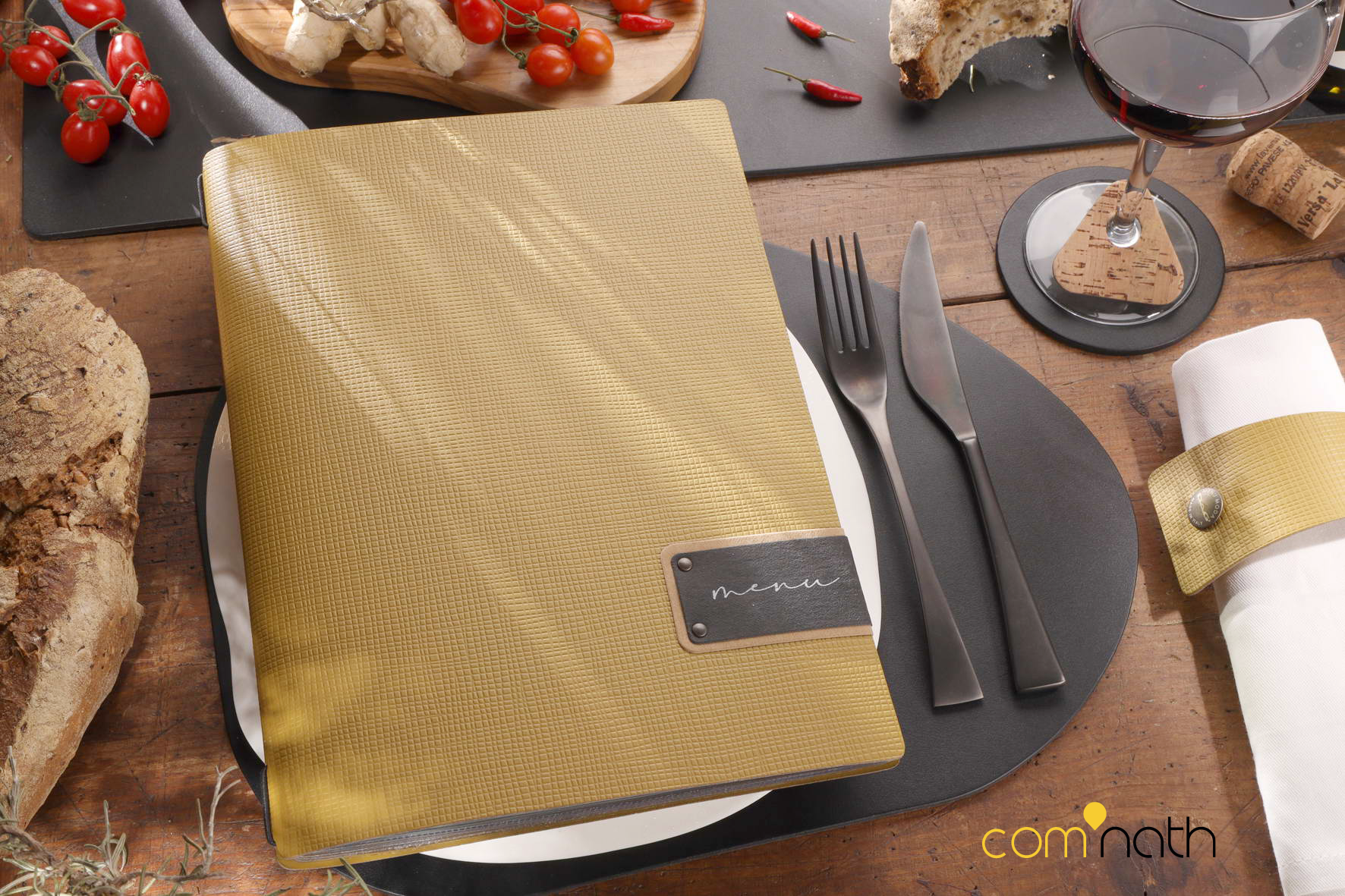 Menu et mise en place : menu recouvert d'or sur une assiette blanche, couverts, pain, vin et nourriture sur une table.