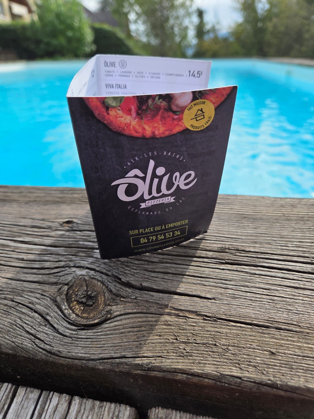 Contenant alimentaire avec reçu, au bord d'une piscine.