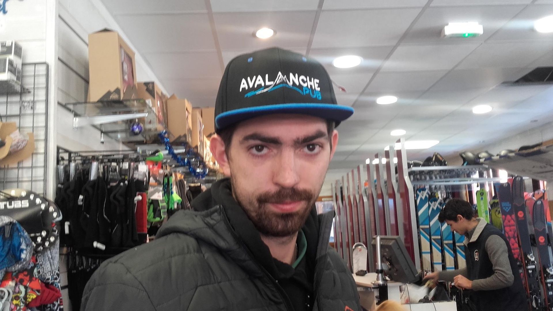 Homme portant un chapeau « Avalanche » dans un magasin de ski.