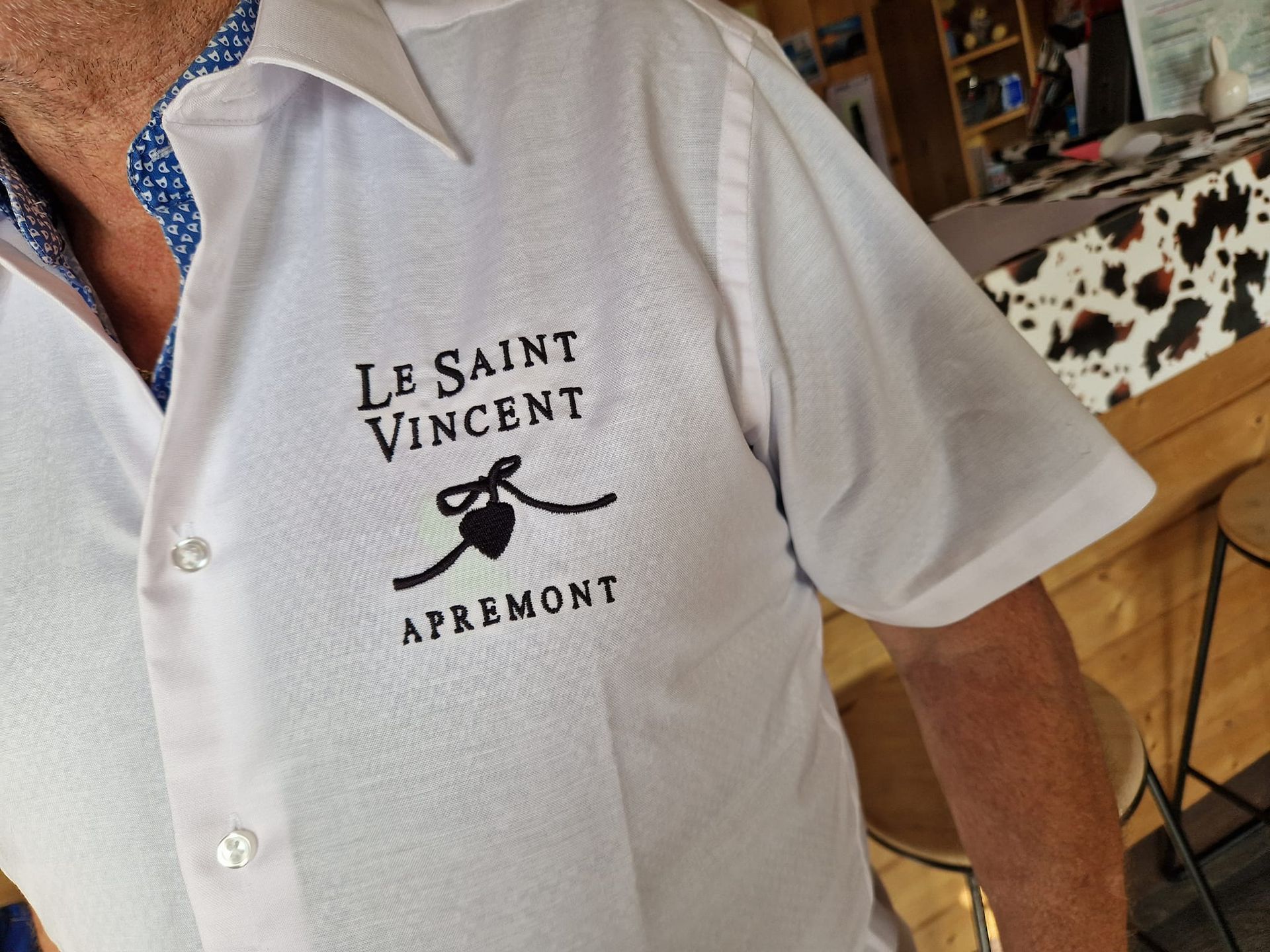 Homme portant une chemise blanche avec le logo 