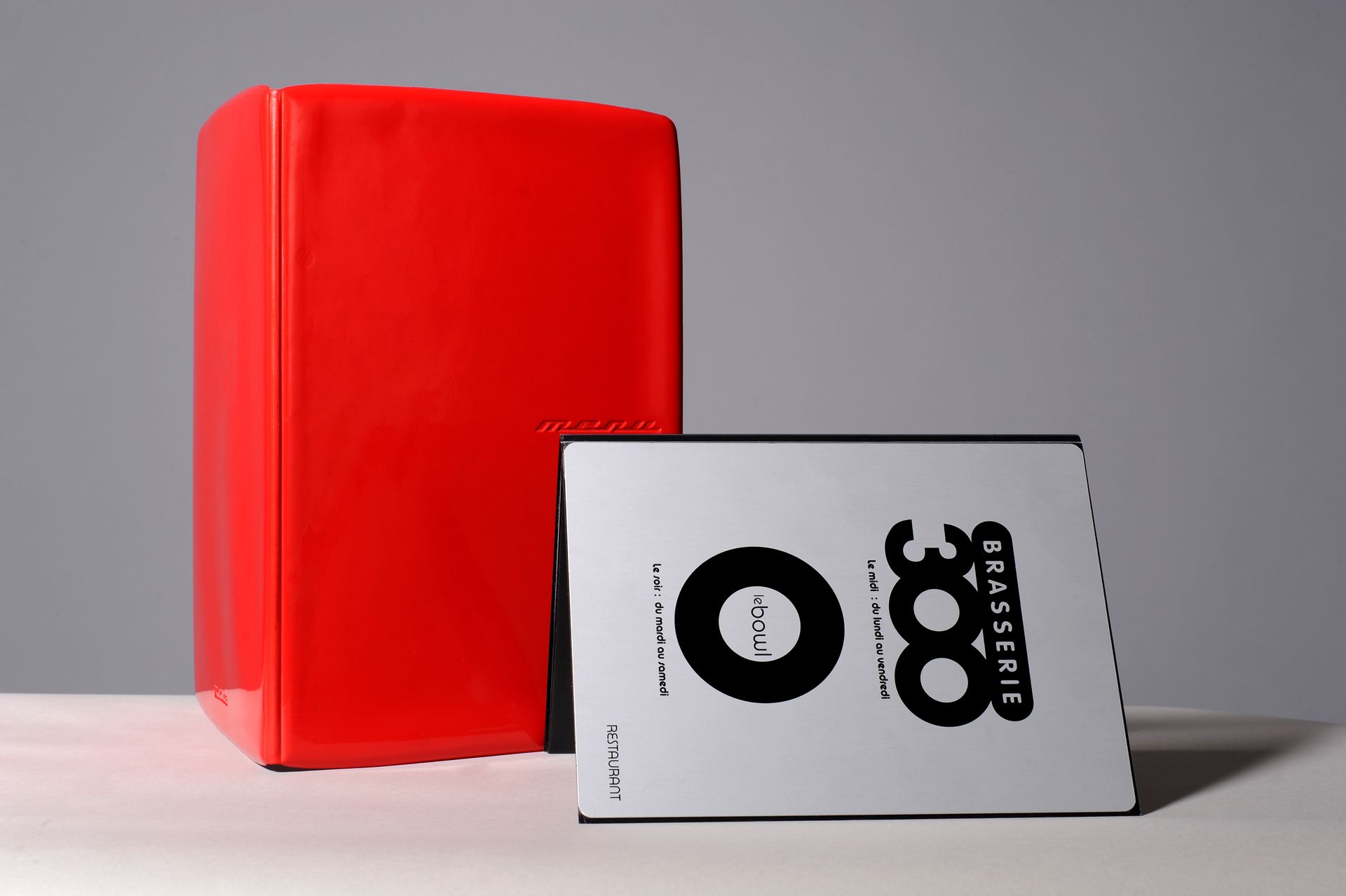 Bloc rouge à côté d'un objet rectangulaire argenté avec le numéro 300.