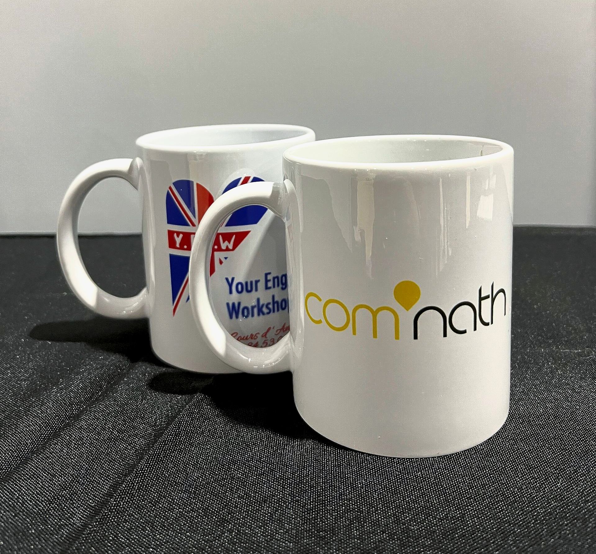 Deux mugs blancs avec des logos ; l'un avec un cœur avec le drapeau britannique, l'autre avec