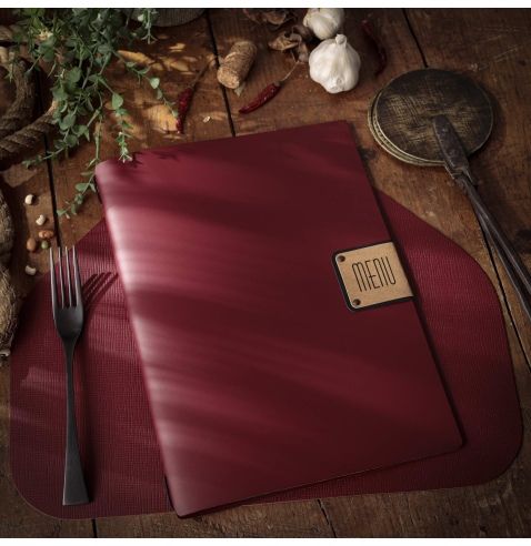 Couverture de menu rouge sur une table en bois avec une fourchette, de l'ail et des herbes.