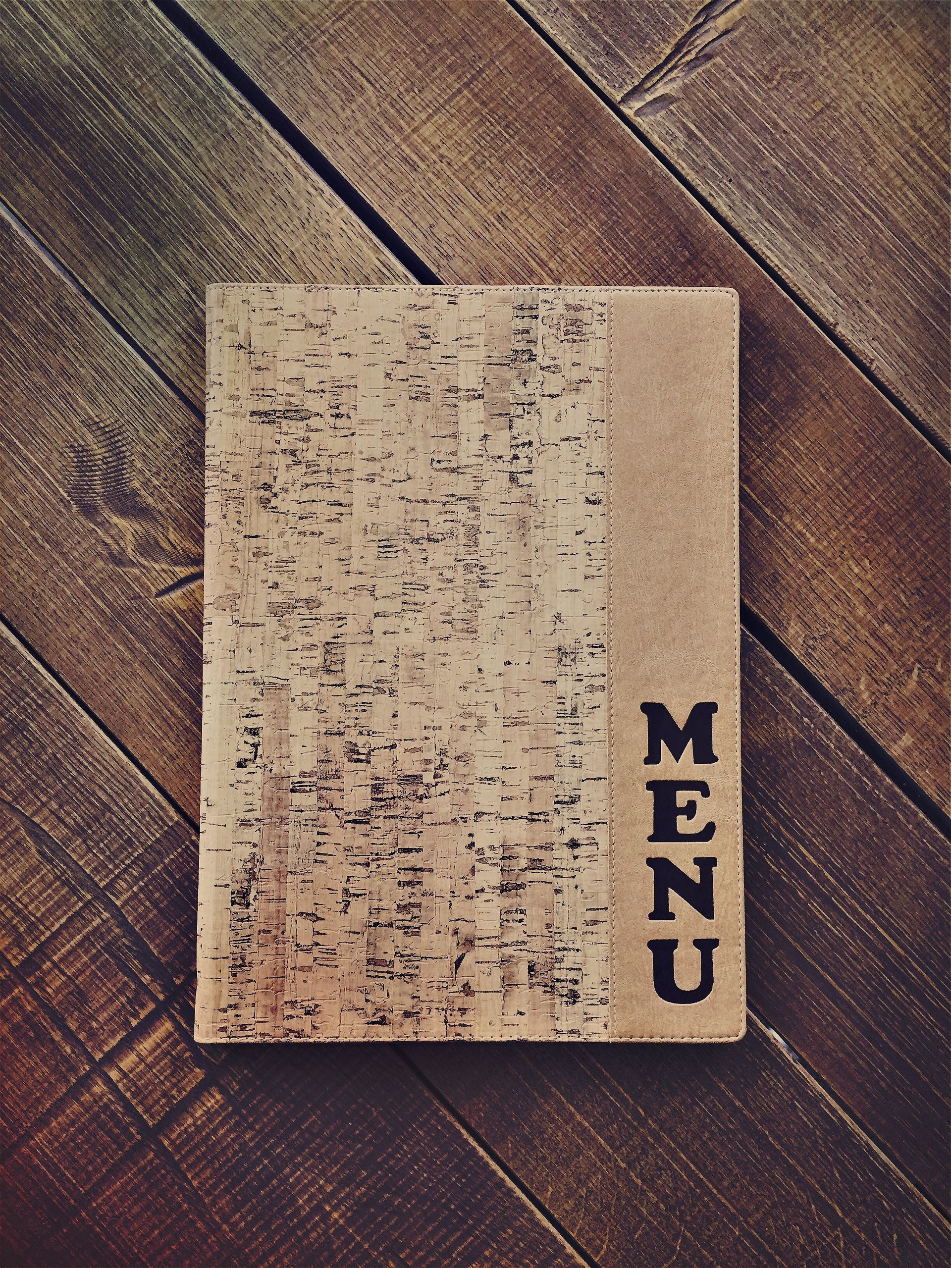 Menu avec couverture en liège sur une table en bois ; 