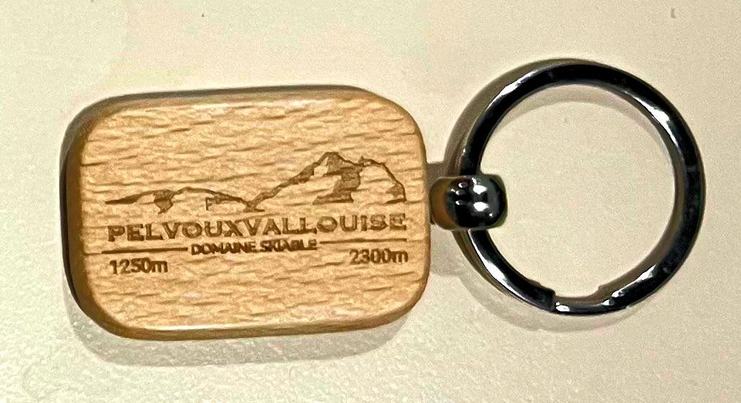 Porte-clés en bois avec montagnes, portant l'inscription 