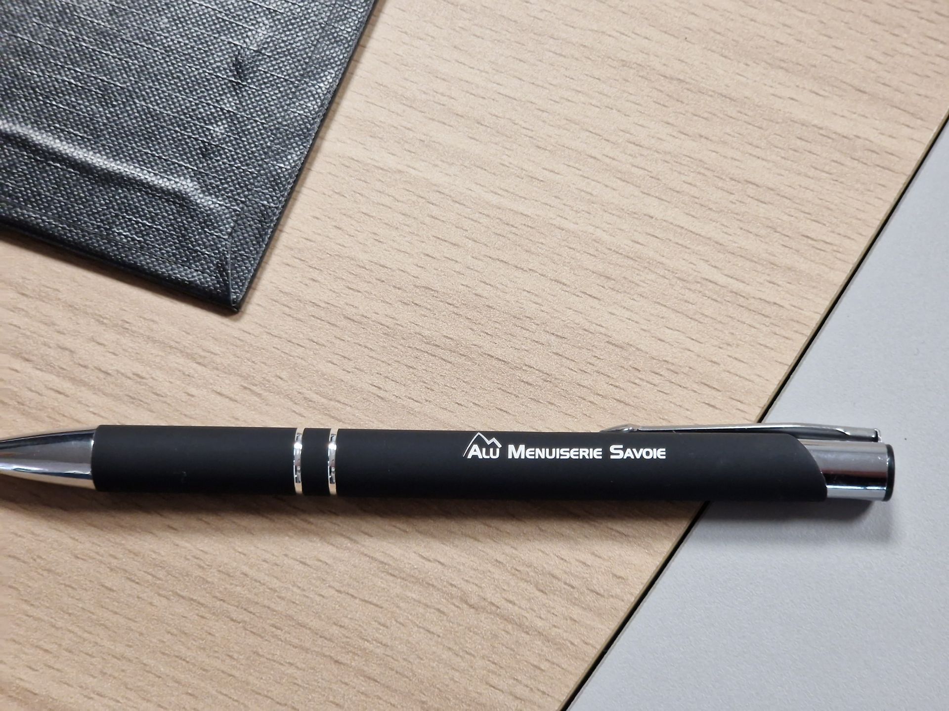 Stylo noir sur table en bois avec le texte « All American Swag ».