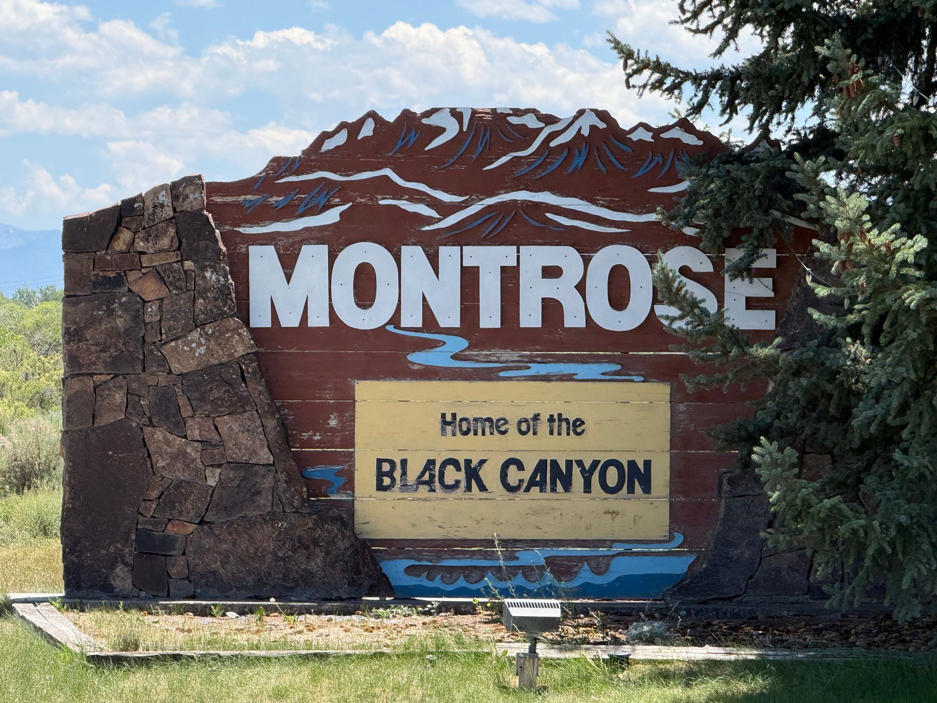 Montrose welcome sign with mountains and “Home of the Black Canyon” text