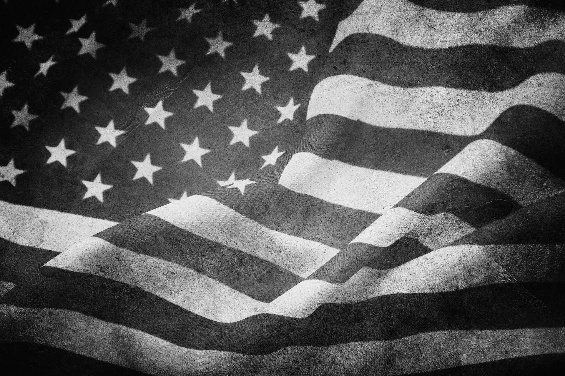 Black and white American flag waving on a textured surface