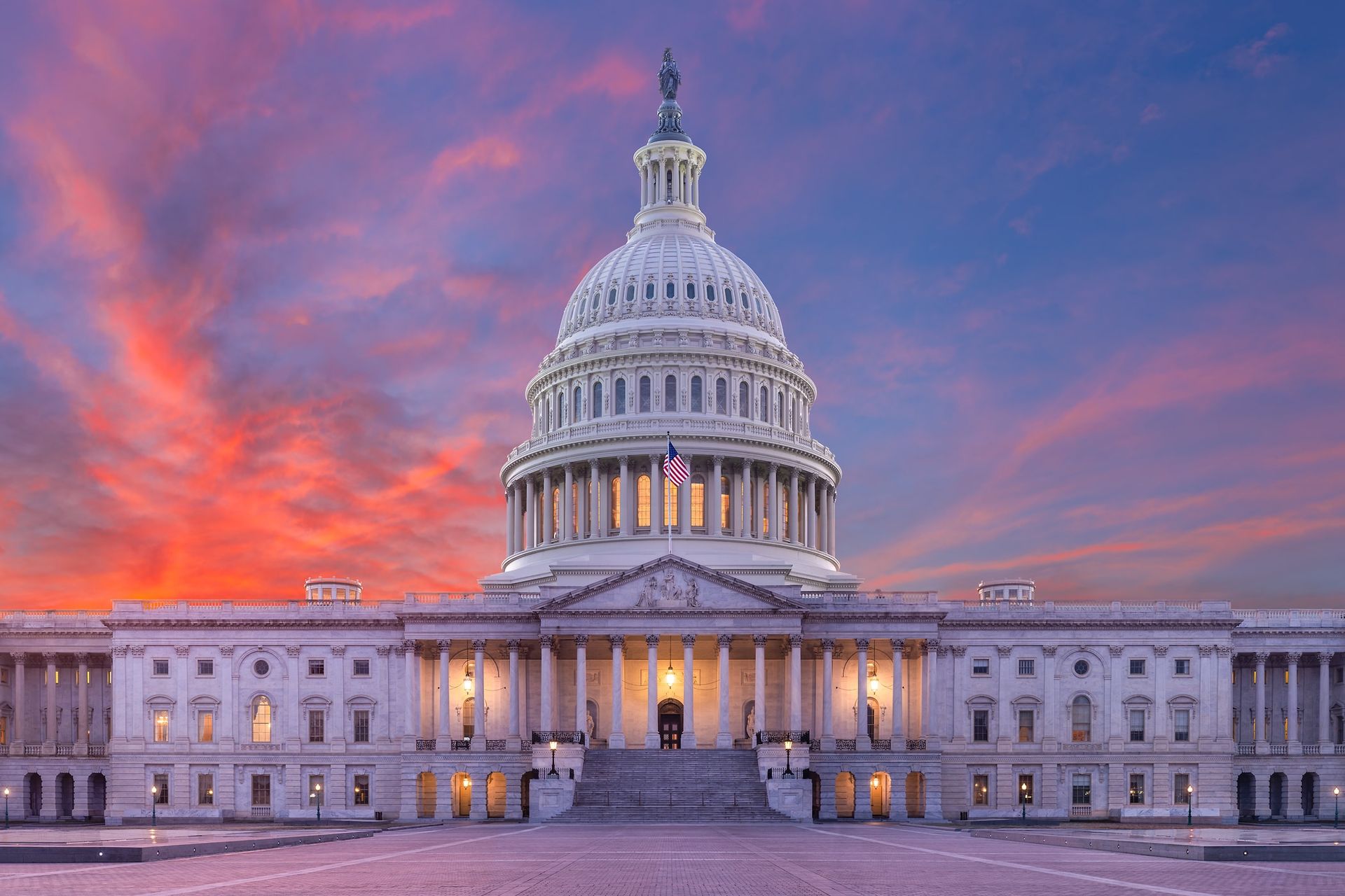 U.S. Capitol building at sunset with a purple-orange sky