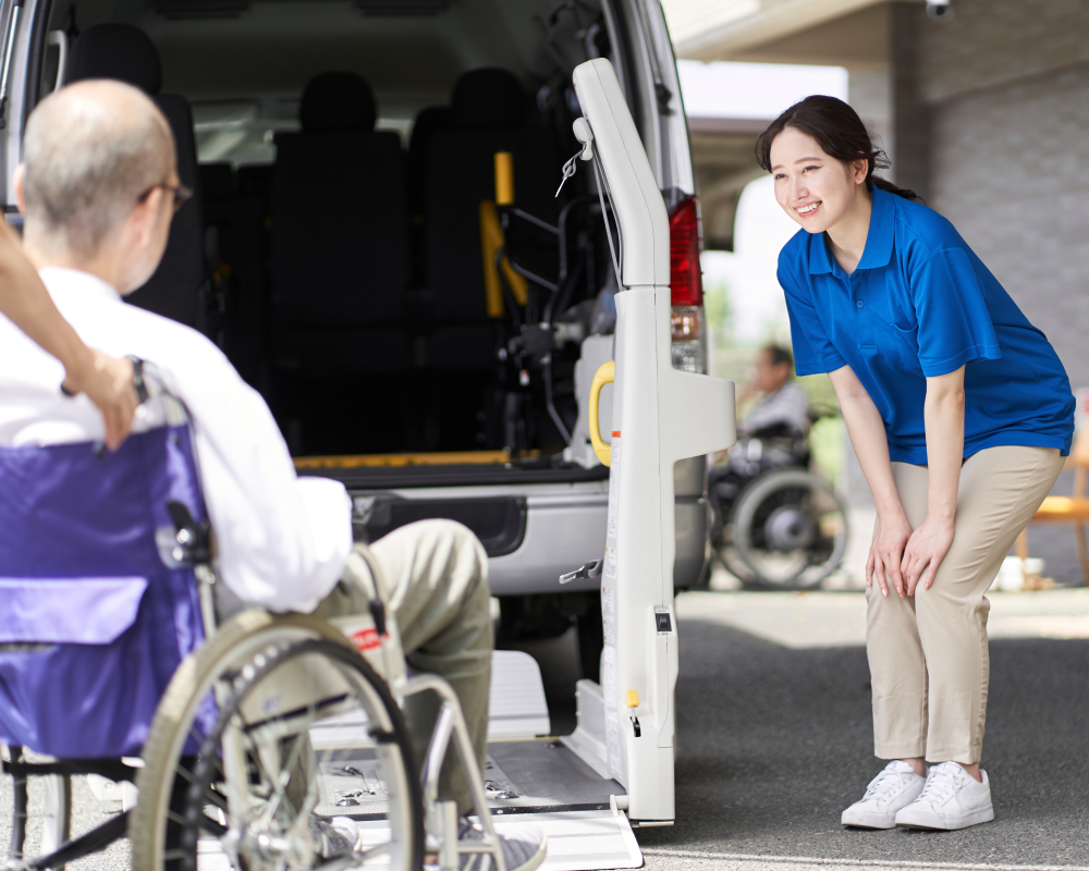 A woman is standing next to a man in a wheelchair.