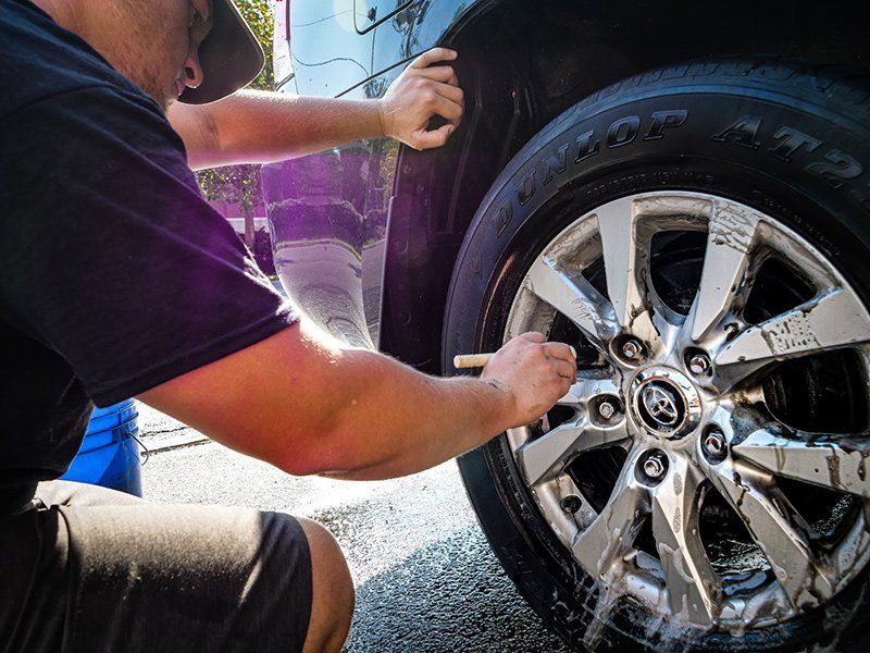 Man Cleaning Tier — Lehigh Valley, PA — Pinnacle Luxury Car Care