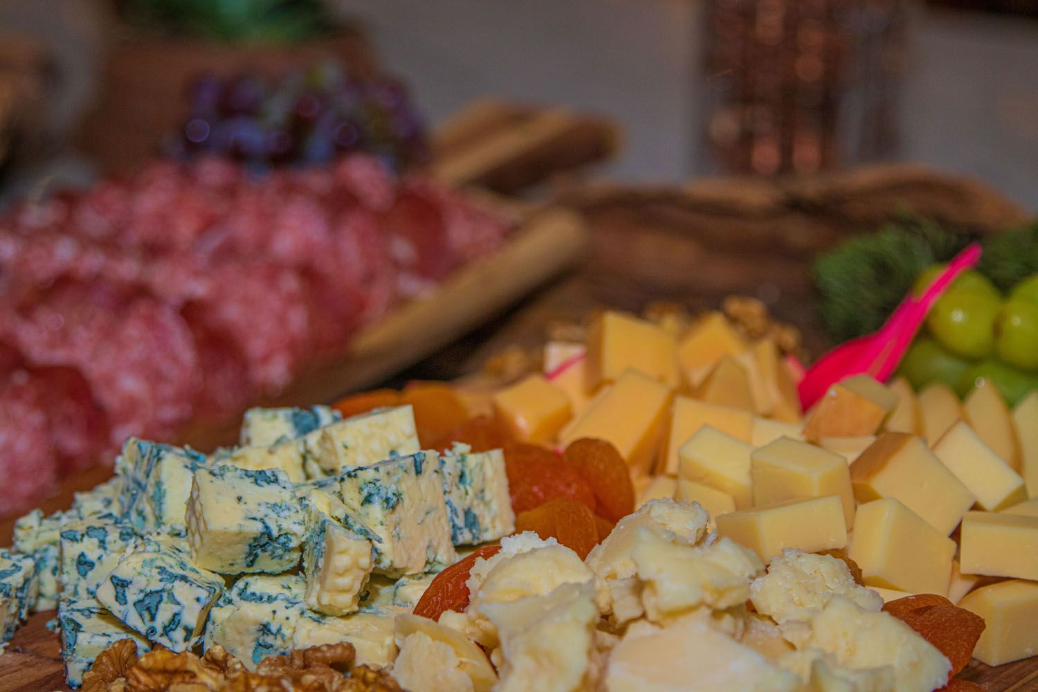 Tábua de frios com queijo azul, salame e vários queijos, nozes e frutas.