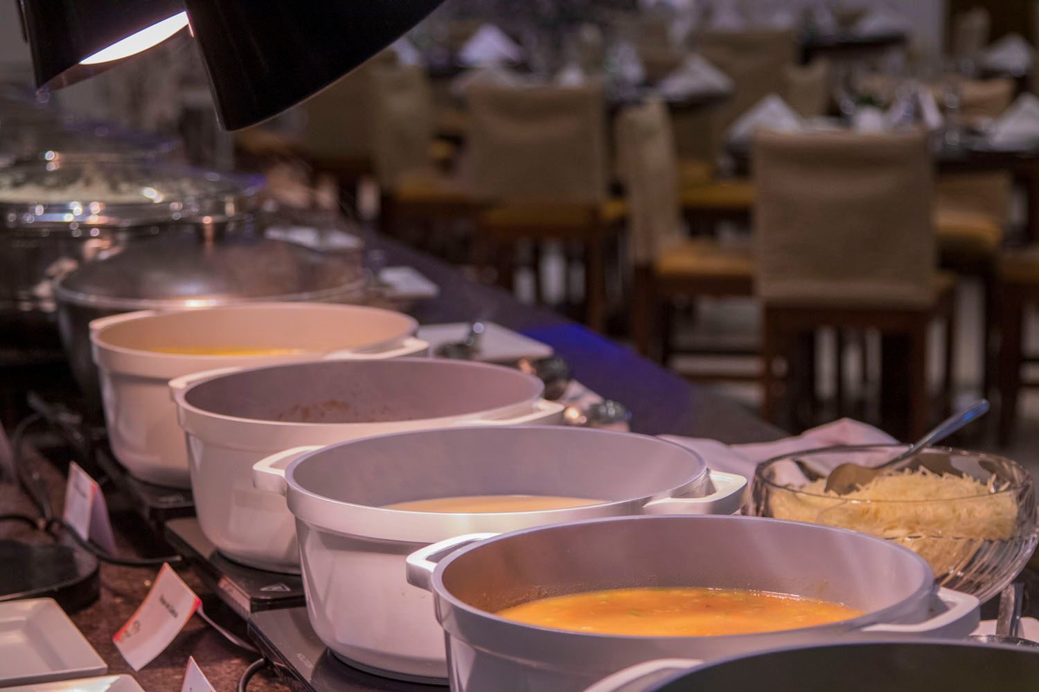 Buffet com várias panelas de sopa quentinhas em um restaurante.