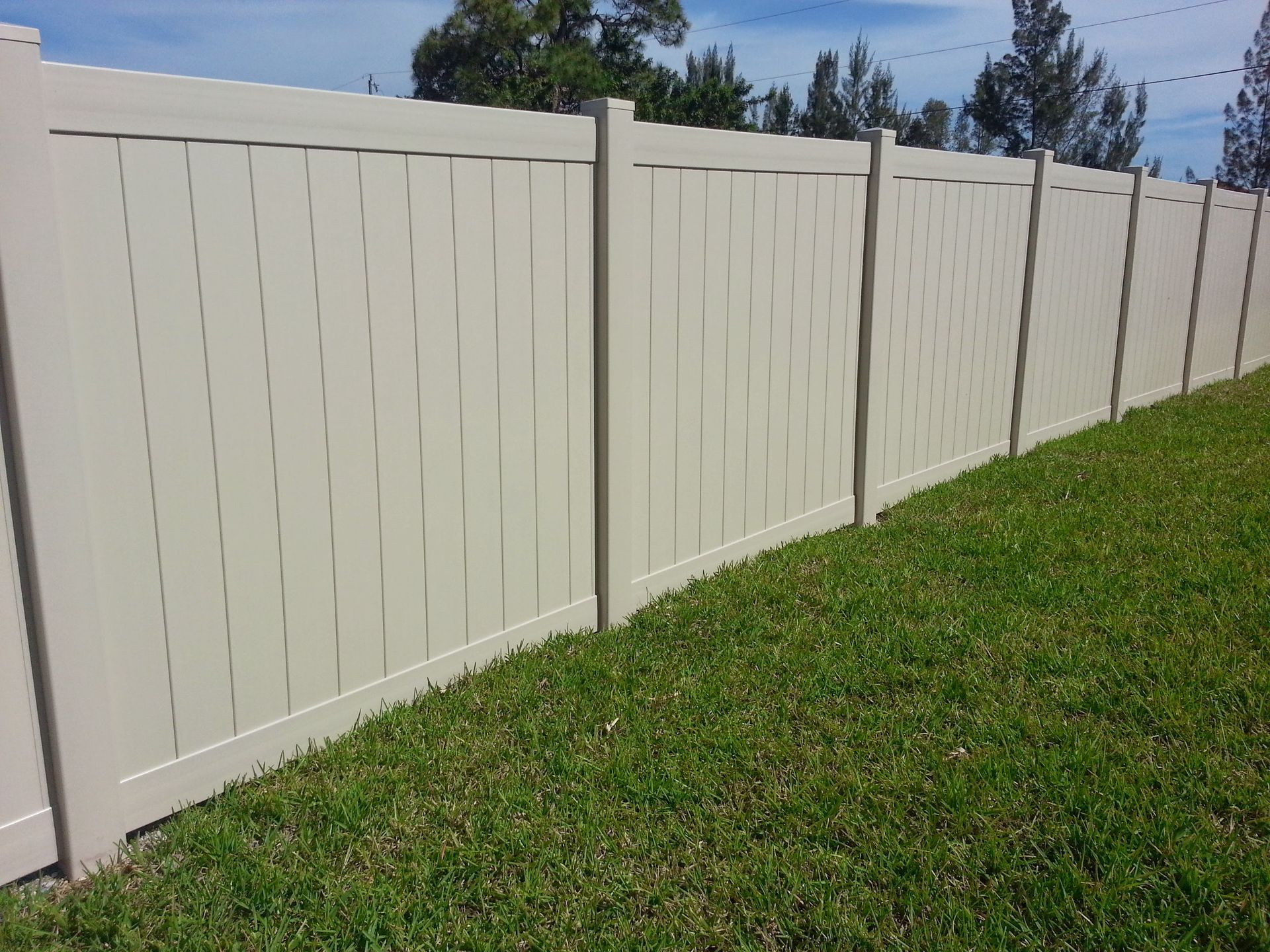 A white fence is sitting in the middle of a lush green field.