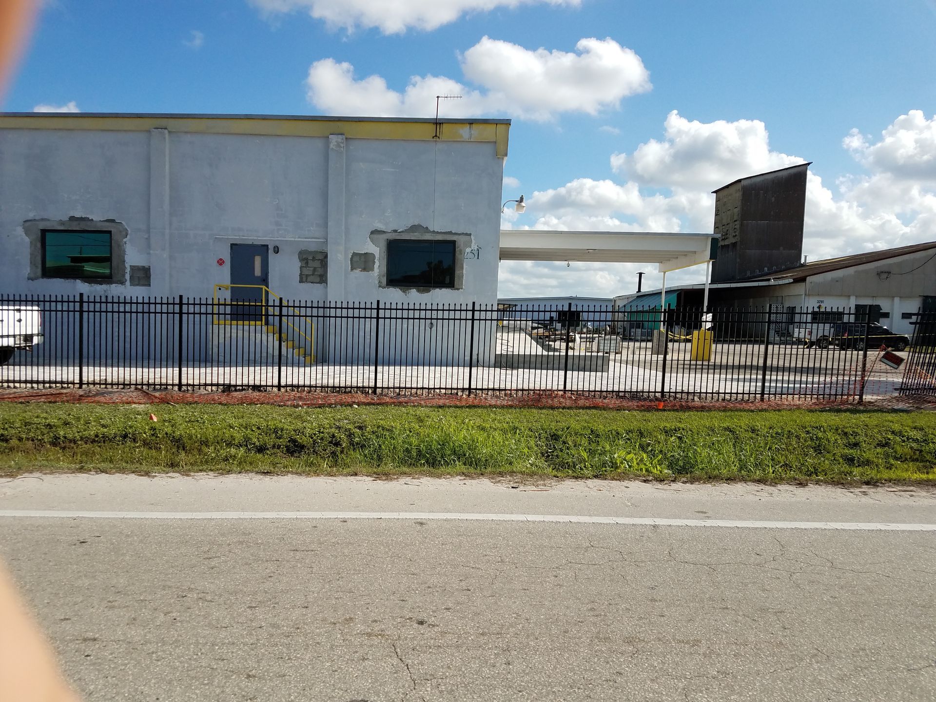 A white building with a black fence around it
