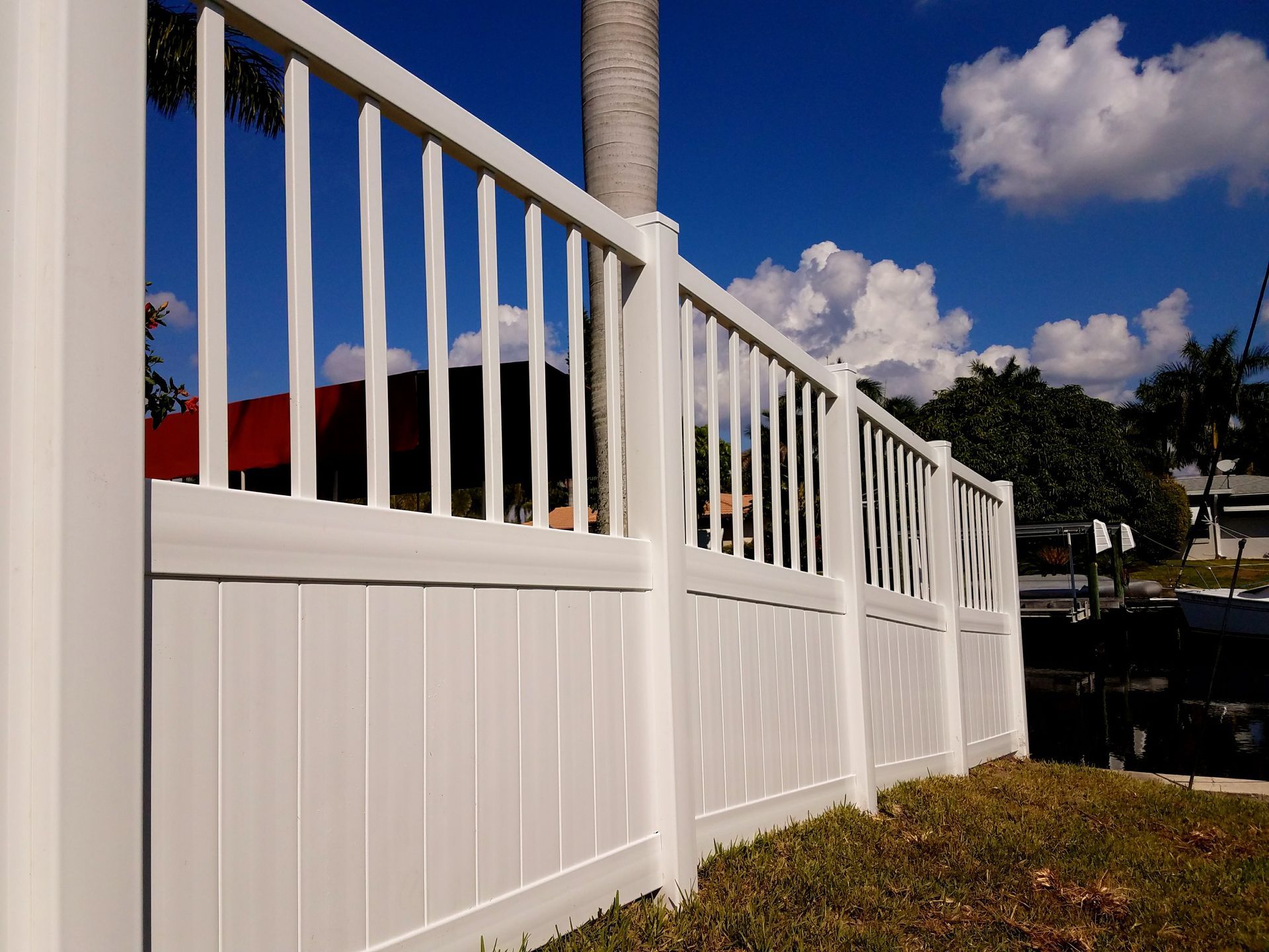 A white fence with a blue sky in the background