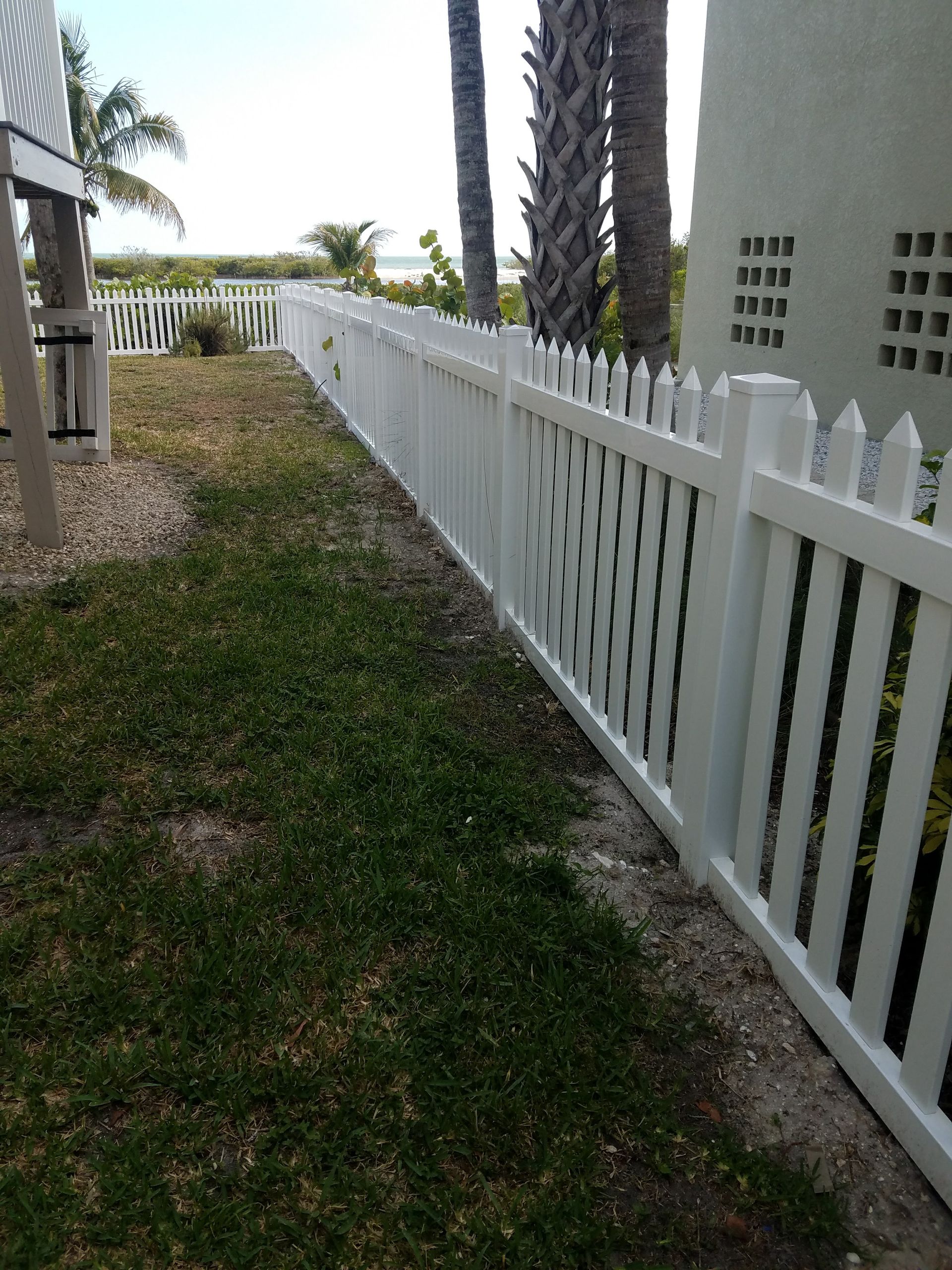 A white picket fence surrounds a lush green yard.