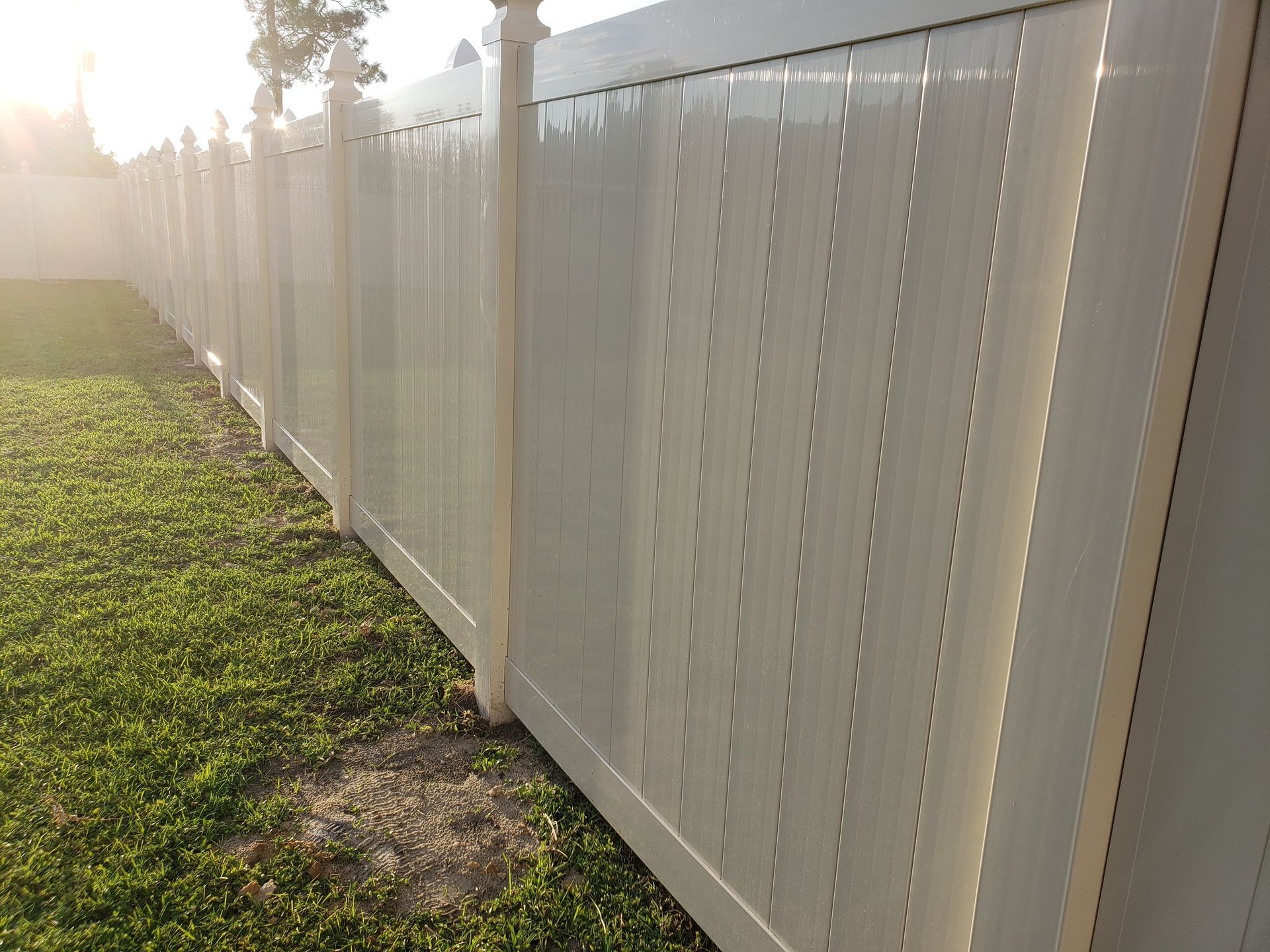 A white fence is sitting in the middle of a lush green field.