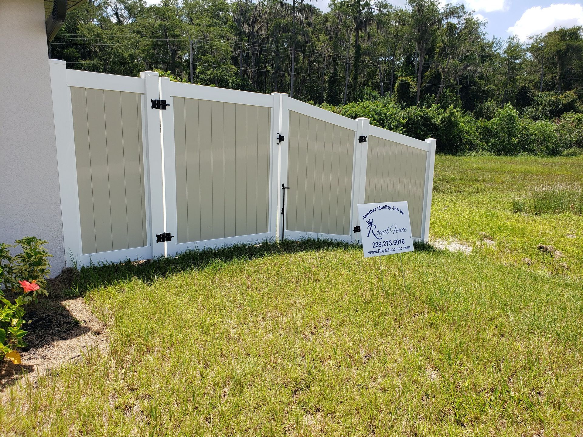 A white fence is sitting in the middle of a lush green field.
